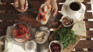 Kahvaltı için humus ve somon sandviç yapma el. Üstten görünüm. Güneşli gün