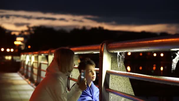 Mujer y niño mirando arañas web por la noche en el parque público — Vídeo de stock