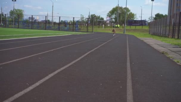 Menina desportiva executando uma corrida de sprint no estádio — Vídeo de Stock