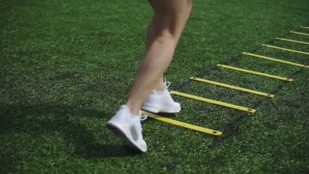 Sportowy dziewczyna robi ćwiczenia na Drabinka koordynacyjna — Wideo stockowe