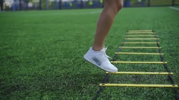 Deportiva chica haciendo ejercicios en la escalera de agilidad — Vídeos de Stock