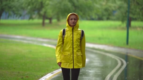 Joven hermosa mujer feliz en impermeable amarillo disfrutando de la lluvia . — Vídeos de Stock