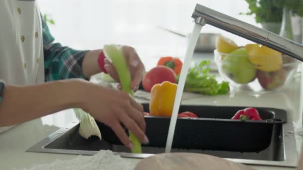 Jovem mulher lavando legumes — Vídeo de Stock