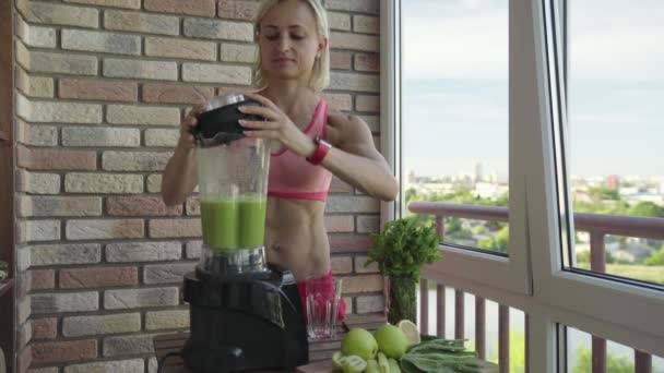 Slim mulher desportiva fazendo um smoothie desintoxicação verde caseiro — Vídeo de Stock