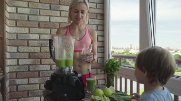 Schlanke, sportliche Frau macht einen hausgemachten grünen Detox-Smoothie — Stockvideo
