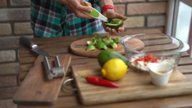 Erkek closeup kesme avokado guacamole ev mutfak masasında için eller