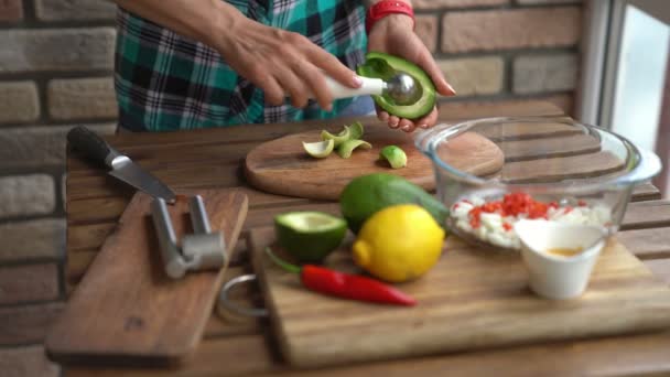 Närbild av kvinnliga händer skär avokado för guacamole på bord i hem kök — Stockvideo