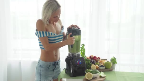 Mujer haciendo batido de verduras verdes con licuadora. Estilo de vida saludable — Vídeos de Stock