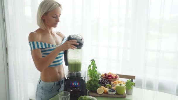 Mujer haciendo batido de verduras verdes con licuadora. Estilo de vida saludable — Vídeos de Stock