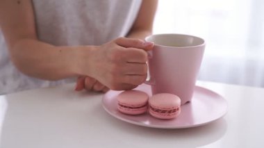 Beyaz kadın beyaz mutfak pembe acıbadem kurabiyesi ile çay içme