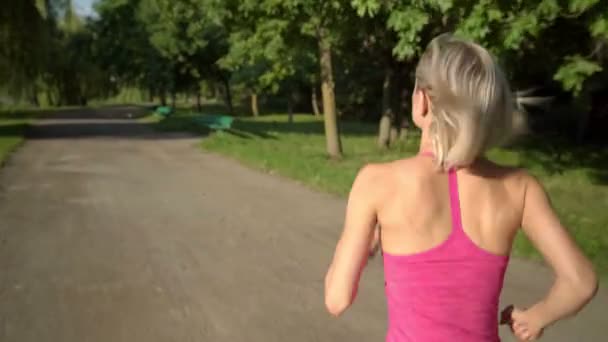 Giovane donna caucasica che fa jogging nel parco pubblico vicino al fiume — Video Stock