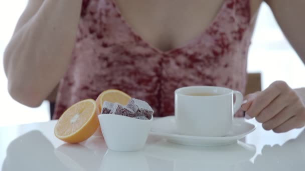 Žena pije čaj a jíst marmeládu na bílý stůl — Stock video