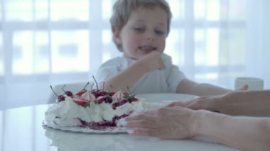 5 yıl yaşlı erkek çocuk tatlı beyaz masada yiyor