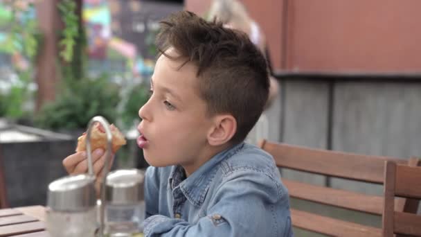 맛 있는 핫도그를 먹는 데님 셔츠에 두 소년. — 비디오