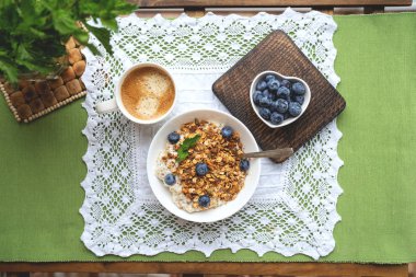 Yulaf ezmesi, granola ve ahşap arka plan üzerinde yaban mersini ile kahvaltı