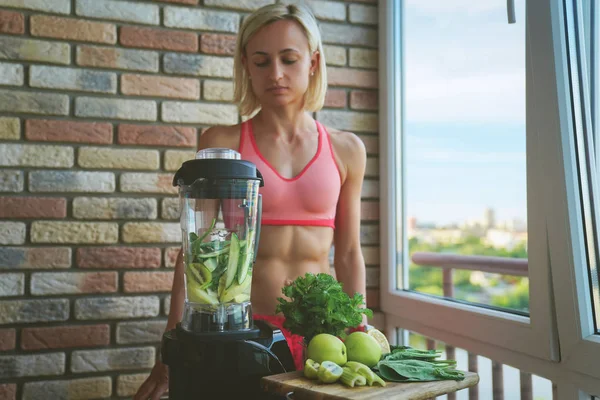 Close-up van jonge vrouw met blender en groene groenten maken detox schudden of smoothie thuis — Stockfoto