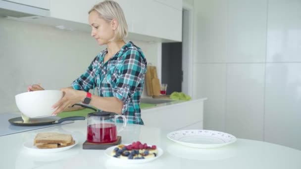 Moeder koken pannenkoeken. Boy is het stelen van pannenkoeken van plaat. — Stockvideo