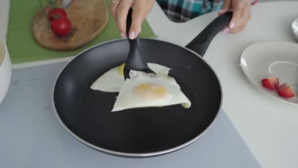 Woman put fried eggs on plaete with toast. Woman set the table for breakfast — Stock Video