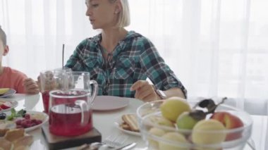 Mutlu genç aile mutfakta kahvaltı. Besleyici yemek.