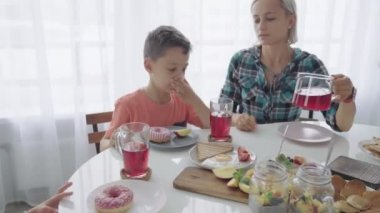 Mutlu genç aile mutfakta kahvaltı. Besleyici yemek.