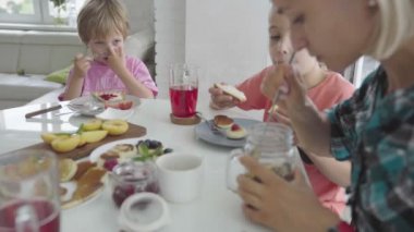 Mutlu genç aile mutfakta kahvaltı. Besleyici yemek.