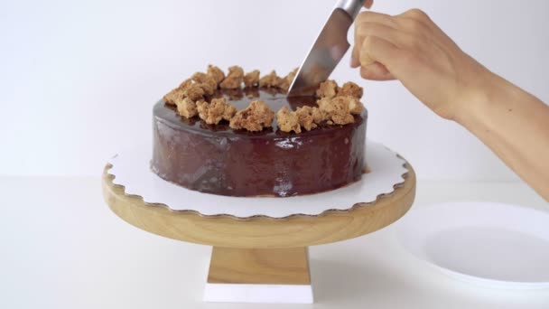 Close up of female hand cutting chocolate glaze mousse cake. — Stock Video