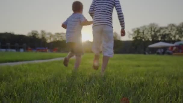 Kinder laufen barfuß über den Rasen. Spaß im Freien — Stockvideo