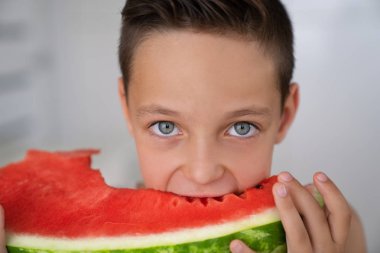 Sulu bir karpuz bir ısırık alarak beyaz çocuk anlamlı gözler,