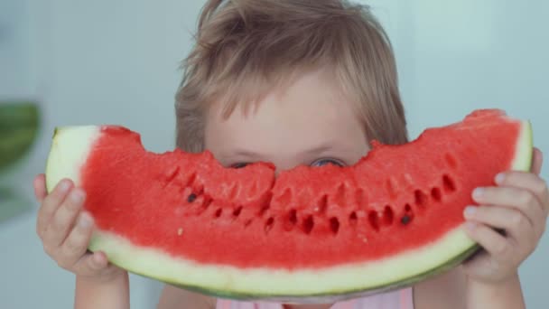 Happy boy appetizing eating red watermelon and juice flowing under the teeth — Stock Video