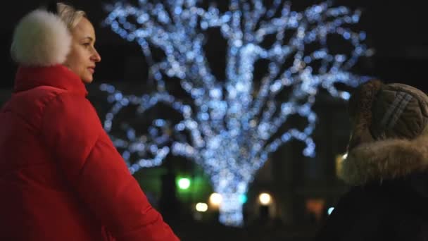 Moeder en zoon in de buurt van de kerstboom in de avond — Stockvideo