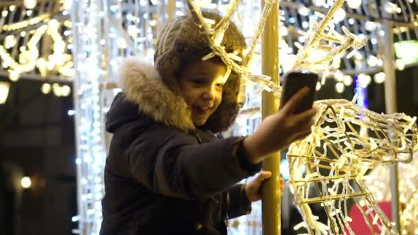 Jongen selfie te nemen op het plein in de buurt van de kerstboom — Stockvideo