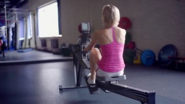Genç atletik kadının kürek makine egzersiz spor yapması
