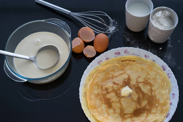 Ingredients for pancake on a black glossy background. Pancake day. — Stock Photo, Image