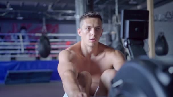 Hombre atlético joven haciendo ejercicio de remo en el gimnasio — Vídeo de stock