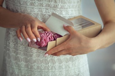 Bir karton kutunun içinde marshmallow tutan kadın