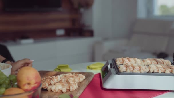 Mujer joven cocinando gofres en la cocina y lindo chico ayuda a su — Vídeos de Stock