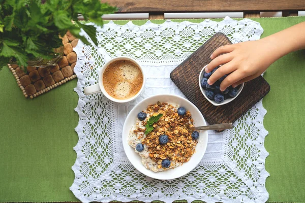 Breakfast with oatmeal, granola and blueberry on wooden background — Stock Photo, Image