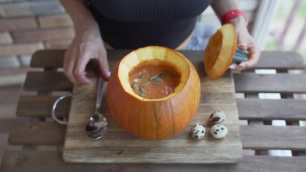 Jovem feliz comendo sopa de abóbora na cozinha — Vídeo de Stock