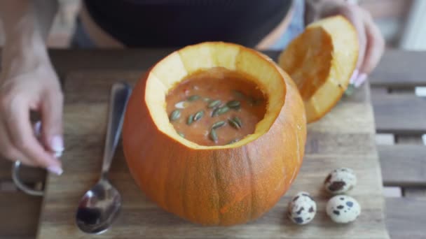 Heureuse jeune femme mangeant de la soupe à la citrouille dans la cuisine — Video