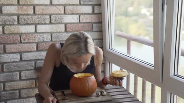 Happy young woman eating pumpkin soup in kitchen — Stock Video