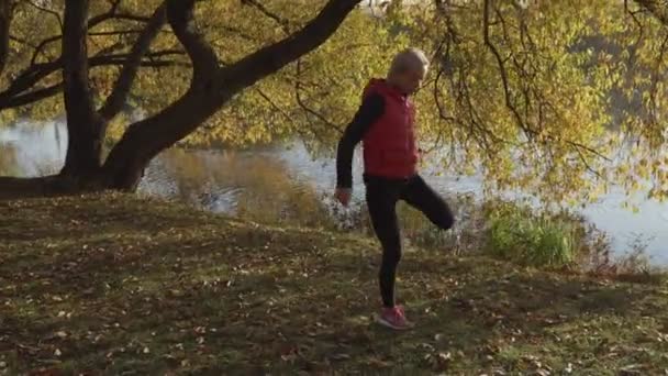 Vrouw runner uitgevoerd in vallen herfst bos. Meisje van de vrouwelijke fitness jogging op pad in de geweldige fall gebladerte landschap natuur buiten. — Stockvideo