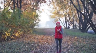 Yoğun bir sis şehir parkında genç bir kadın sabah koşuya. Herhangi bir hava kavramı içinde sağlıklı yaşam tarzı
