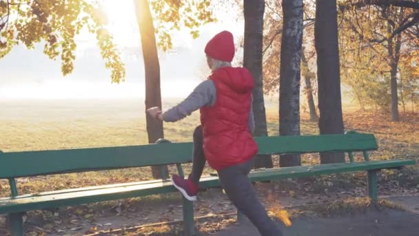 Kör stretching. Kvinnan sträcker benet som uppvärmning innan du kör med sport aktivitet — Stockvideo