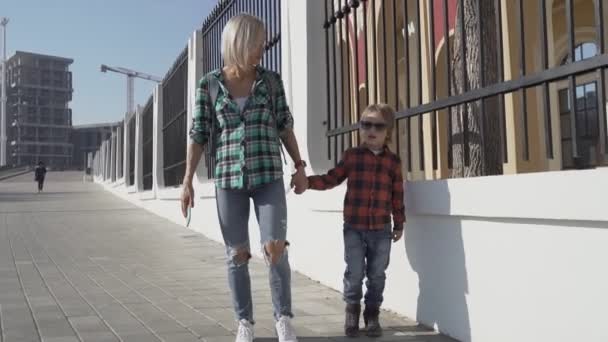 Un niño y su madre están caminando por el casco antiguo. Una mujer viaja con su hijo en lugares históricos . — Vídeo de stock