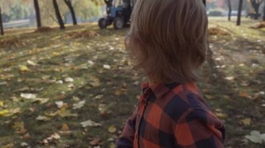 Küçük çocuk sonbahar düşen yapraklar çalıştıran