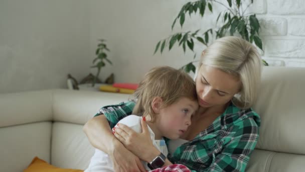 Mãe medir a temperatura de seu filho doente no fundo. Criança doente com febre alta deitada no sofá em casa — Vídeo de Stock