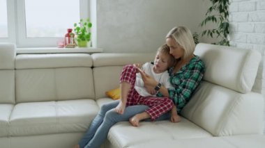 Annesi hasta çocuğunu arka plan, sıcaklığı ölçme. Yüksek ateşle evde kanepe yalan hasta çocuk