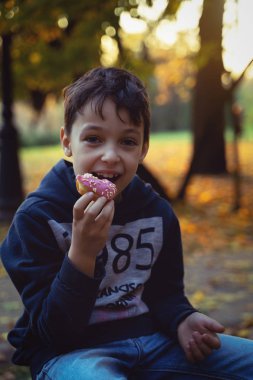 Genç beyaz çocuk 8 yaşında halka açık havada tatlı yeme. Çocukluk.