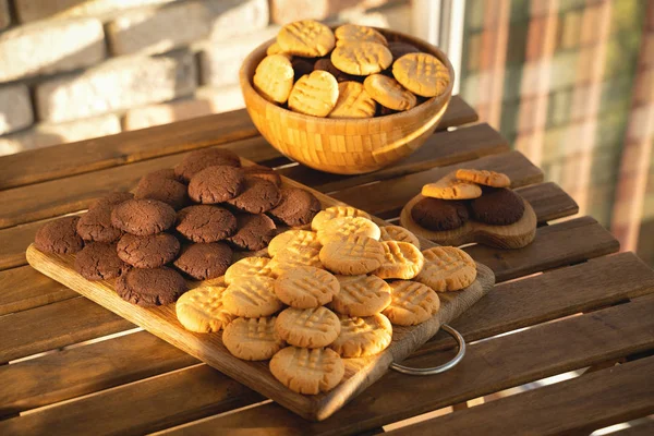 Biscoitos de amendoim e chocolate em fundo de madeira em raios de sol — Fotografia de Stock