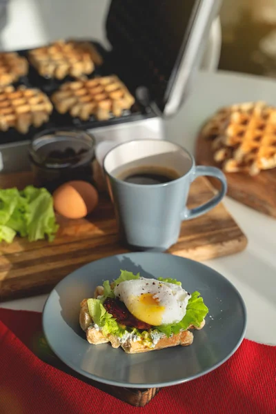 Ägg Benedict med bröd och tomatsoppa på en tallrik med becon morgon smörgås — Stockfoto